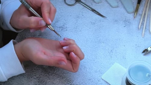 Hands Doing Manicure with Metal Cuticle Tool