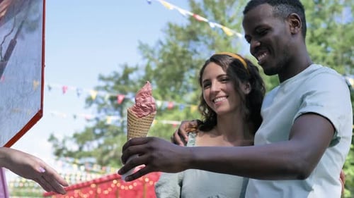 Romantic Couple Receives Ice Cream in Park on Summer Day
