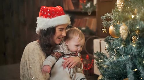 Mother and Infant Enjoying Christmas Tree Together