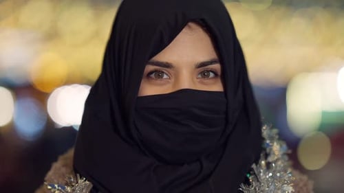 Nahaufnahme Positive Frau aus dem Nahen Osten im Kopftuch, das Gesicht bedeckt und mit haselnussbraunen Augen in die Kamera
