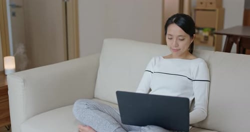 Woman Working on Laptop from Home on Sofa