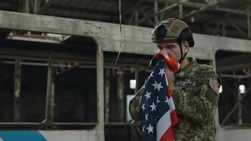Man in Military Uniform Holding American Flag
