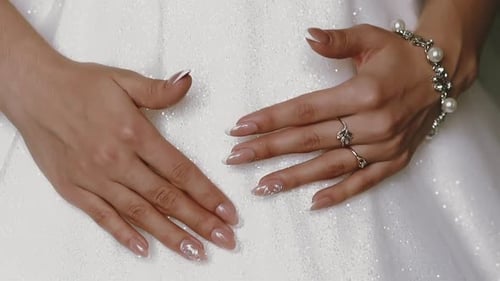 Elegant Bride's Hands Adorned With Jewelry on Dress