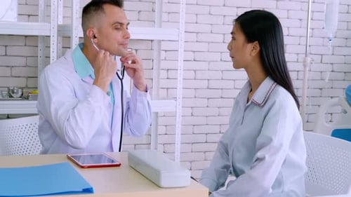 Doctor in Professional Uniform Examining Patient at Hospital