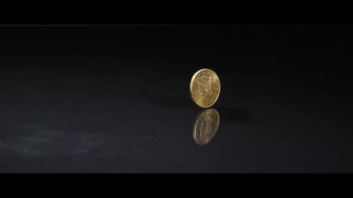 Golden Coin Spinning on Reflective Black Surface