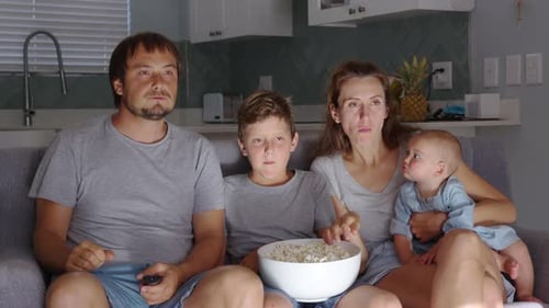 Family Watching TV and Eating Popcorn at Home