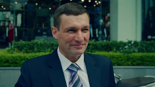 Man in Suit Drinks Coffee Outside Shopfront