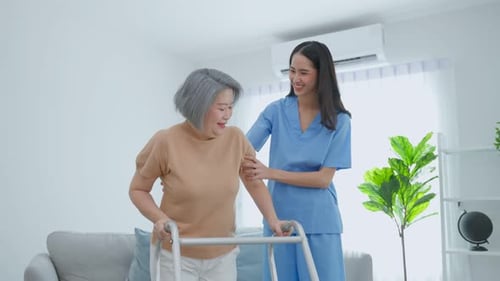 Senior Woman Uses Walker with Support from Nurse
