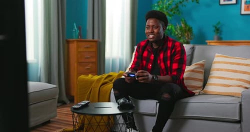 Adult Playing Video Games on Couch at Home