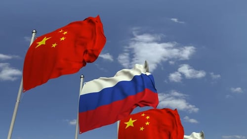 Waving Flags of Russia and China in a Blue Sky