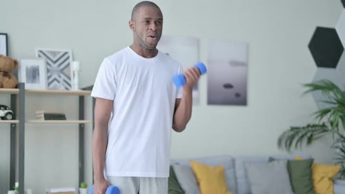 Young Adult Doing Bicep Curls with Dumbbells at Home