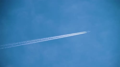 Airplane Flying Leaving White Contrail In Clear Blue Sky