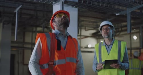 Engineer Showing Workshop To Inspector Using Tablet