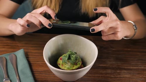 Woman Photographing Food with Smartphone at Restaurant