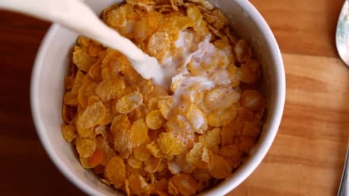 Pouring Milk on Cornflakes for Breakfast