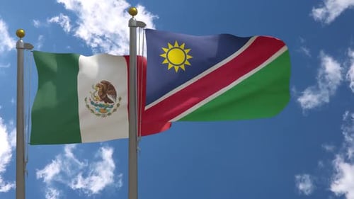 Mexico and Namibia Flags Waving Against Blue Sky