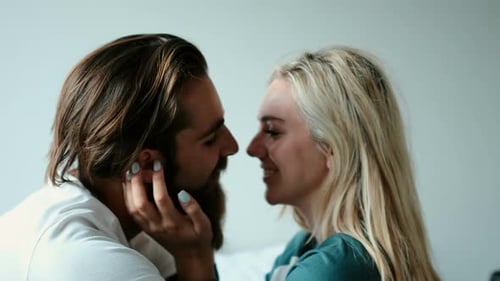 Affectionate Couple Kissing Indoors with Soft Light