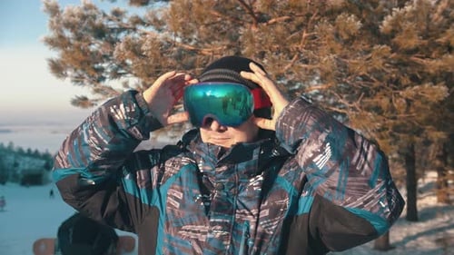 Man Snowboarder Putting on Glasses