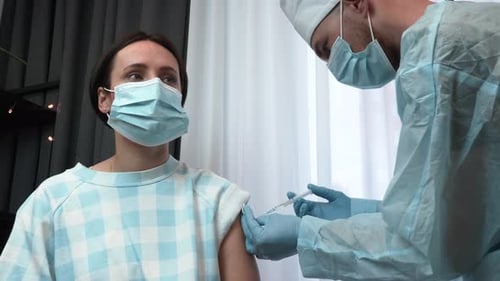 Healthcare Worker Giving Young Adult Woman Injection