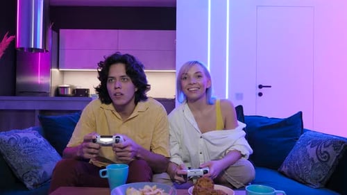 Young Couple Playing Video Games and Celebrating Victory