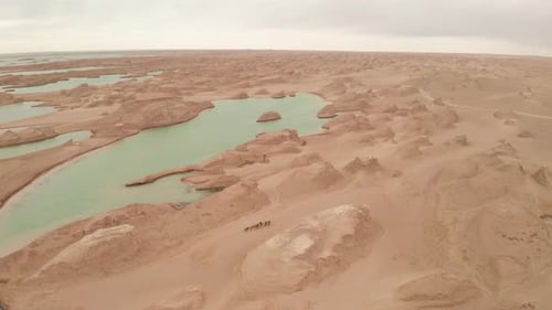 Desert Landscape Featuring Rock Formations and Turquoise Water