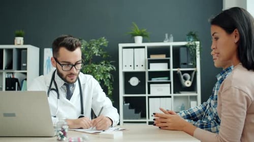 Young Woman and Small Boy Discussing Health Issues with Male Doctor in Modern Hospital