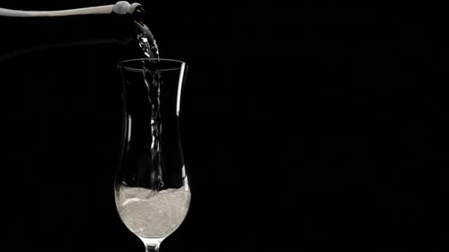 Elegant Champagne Being Poured into Tall Glass