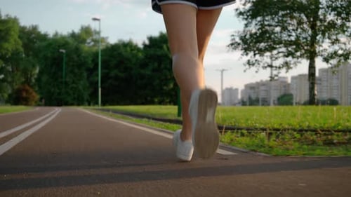 Young Fitness Sport Woman Running on Road at Sunset