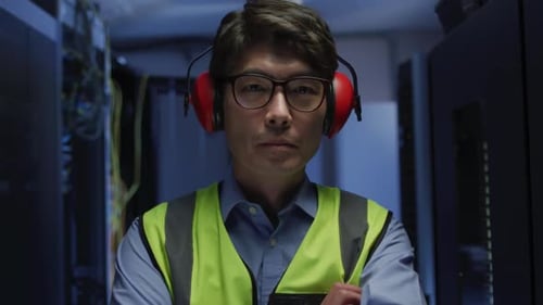 Man Stands in Dimly Lit Data Center
