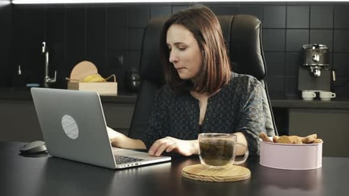 Woman Opens Laptop and Works at Desk