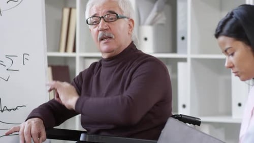 Man in Wheelchair Leading Meeting in Office