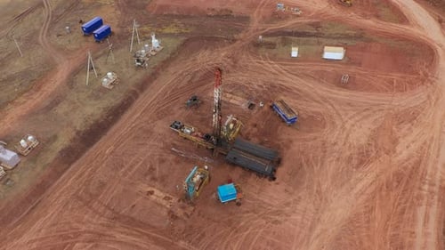 Oil Workers Work with an Oil Rig in an Oil Field