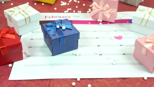 Gift boxes sit on calendar with heart on February 14th