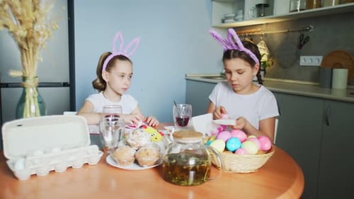 Funny Little Sisters Wearing Bunny Ears Painting Eggs on Easter Day