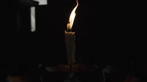 Burning Candle Flame in the Darkness