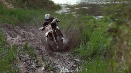 Motorcycle Races Through Muddy Off-Road Nature Trail
