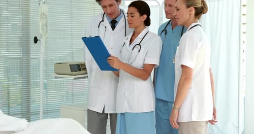 Medical Team Attending Patient in Hospital Room