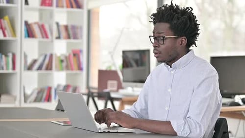 Young Adult Working on Laptop in Office