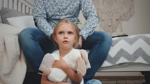 Dad Styles Young Daughter's Hair at Home