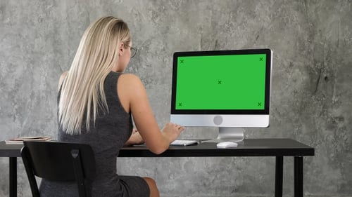 Businesswoman using desktop computer in creative office.