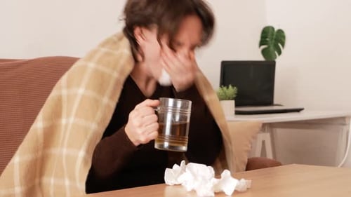 Sick Man With Cold Blows Nose at Home