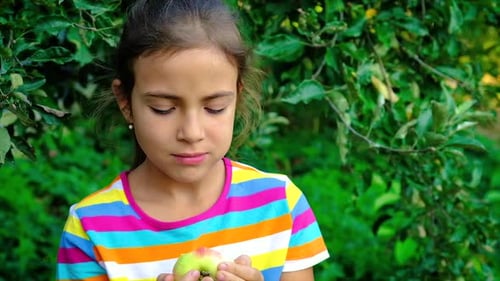 The Child Eats an Apple in the Garden