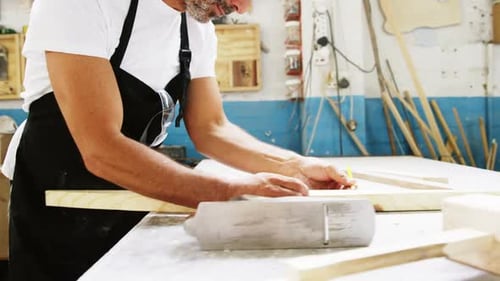 Craftsman Marking Wood Lumber in Workshop