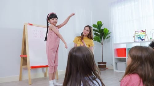 Caucasian beautiful woman teacher teaching a lesson to kid at school.