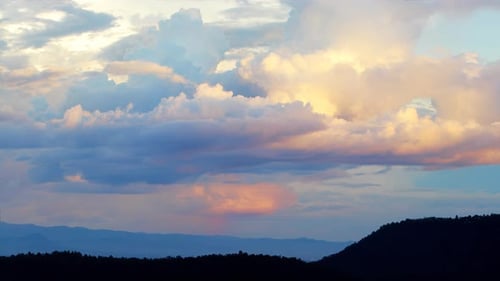 Magische blaue und orange Wolken wirbeln bei Sonnenuntergang über dem Berg