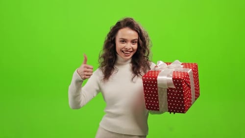 Woman Holds Birthday Gift Gives Thumbs Up