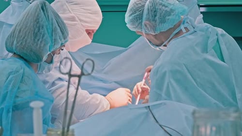 Surgeons Performing Intricate Operation in Hospital Operating Room