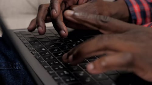 Close Up African American Man Hands Typing Text on Keyboard Laptop at Home