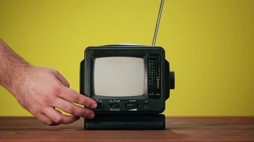 Hand Turns On Retro TV Showing Static