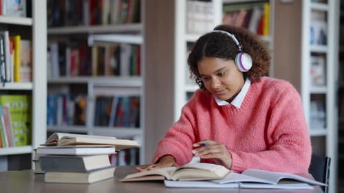 Afroamerikanischer Student schreibt Hausaufgaben und hört Musik